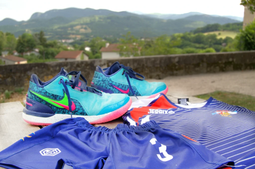 Des habits et chaussures de sport. Le paysage du Couserans au fond